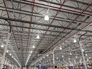 Large warehouse illuminated with numerous lights and a multitude of spotlights on the ceiling