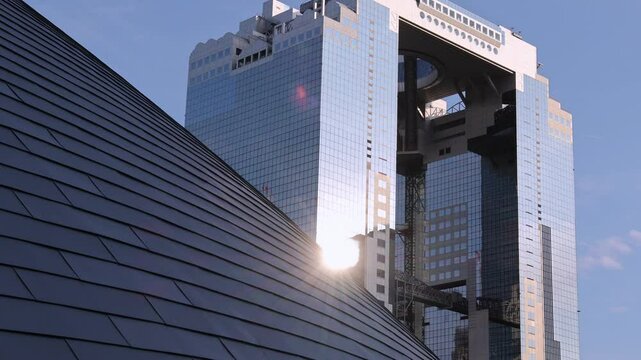 Umeda Sky Building in Osaka Japan and sunlight in evening. Landmark features a unique floating garden observatory connecting twin towers at top. Umeda Sky Building One of Osaka Landmark travel spot.