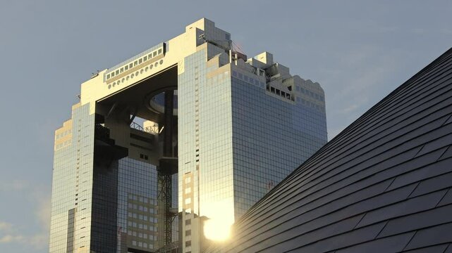 Umeda Sky Building in Osaka Japan and sunlight in evening. Landmark features a unique floating garden observatory connecting twin towers at top. Umeda Sky Building One of Osaka Landmark travel spot.