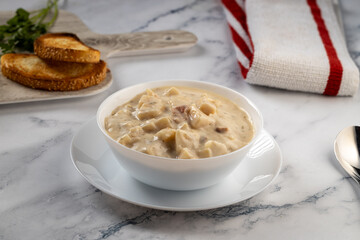 Steaming bowl of soup with hearty bread slices.