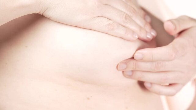 Woman checking her breast for signs of breast cancer. Early detection. Breast Self Exam - BSE.