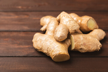 Fresh ginger on wooden background. Dry ginger. Sliced ​​ginger with honey and lemon. Ginger root. Traditional alternative medicine, healing tea for immunity. Seasoning and spices concept. Copy space.