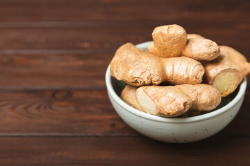 Fresh ginger on wooden background. Dry ginger. Sliced ​​ginger with honey and lemon. Ginger root. Traditional alternative medicine, healing tea for immunity. Seasoning and spices concept. Copy space.