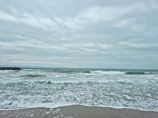 Waves reaching the shore on a stormy day, leaving behind foam
