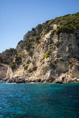 Fototapeta premium Idyllic Landscape of Rock Formation with Trees in Zakynthos. Rocky Cliff with Ionian Sea during Summer Sunny Day in Greece.