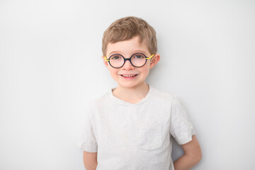 portrait of handsome little boy in glasses isolated on gray background