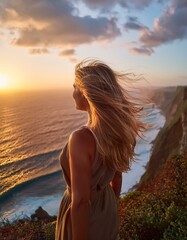 A person standing at the edge of a cliff during sunset, overlooking a vast ocean, with the wind blowing through their hair, evoking a sense of adventure and introspection