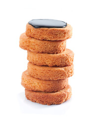 Stack of golden cookies topped with dark chocolate glaze in a bright setting