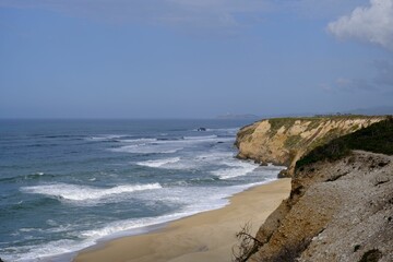 Serene coastal landscape with cliffs and beach.