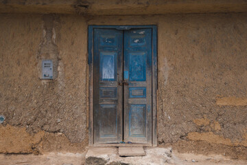 Closed door in an aged adobe wall