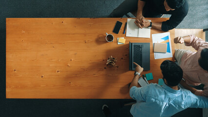 Top view of business team looking at laptop while giving high five and clinking glass to celebrate...