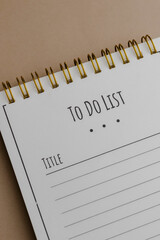 A notebook with 'TO DO LIST' and 'TITLE' printed on the pages is pictured. It has a spiral binding...