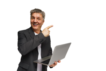 Man in business suit smiling and holding laptop while pointing to the side in a bright studio setting