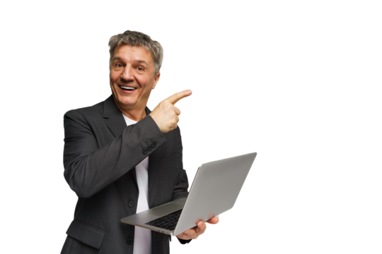 Man in business suit smiling and holding laptop while pointing to the side in a bright studio setting - Powered by Adobe