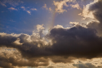 A sky with cirrus clouds and a halo effect. A majestic natural phenomenon with a bright light ring against delicate clouds. An optical halo phenomenon in the daytime sky