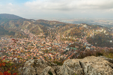 Obraz premium View from Tampa mountain in Brasov, Romania, on the city of Brasov during rainy and cloudy autumn day. Dark clouds, bad weather. Some old buildings are modern concrete buildings. Eastern europe.