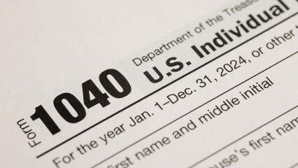 A close-up shot showcases the U.S. Individual Income Tax Return Form 1040 for the year 2024,...