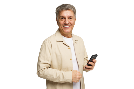 Smiling man holding smartphone while wearing a casual beige jacket in a studio setting