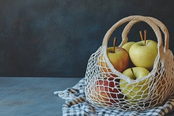 Red and yellow apples in a mesh bag on a gray checkered blanket produce a serene, rustic look. Copy space, eco-friendly approach