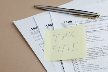 Tax Season Reminder: Tax forms and pen on a table.  Tax planning, financial paperwork, and deadlines loom. Time to organize documents and file returns.