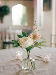 Beautiful floral arrangement in a glass vase on a table at a cozy venue during a serene gathering