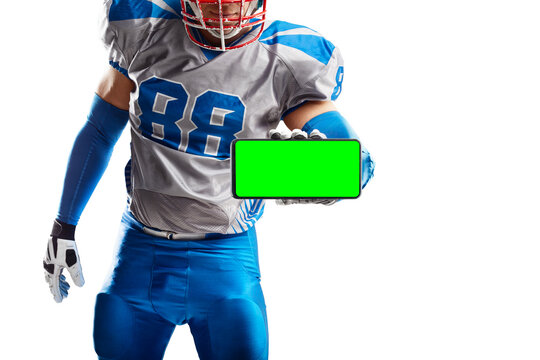 Chroma key. American football player holding a phone. Phone with chroma key for promo advertising, presentation mockup, bookmaker advertising and UI. Football - Powered by Adobe