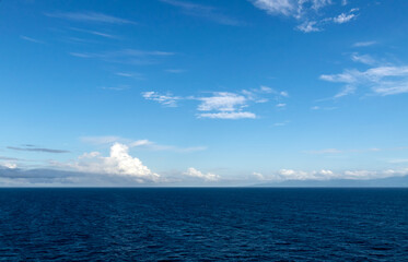 Panoramic view over the Pacific Ocean towards the coast of Panama, where the silhouettes of the mountainous terrain are visible.