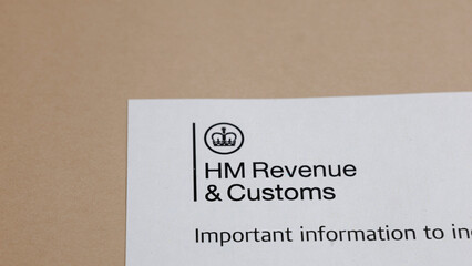 A document featuring the crest and title of a revenue and customs office, laying on a desk,...