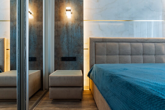 A cozy bedroom that features a comfortable bed, a stylish nightstand, and beautiful mirrors to enhance the rooms appearance and functionality, creating a relaxing atmosphere