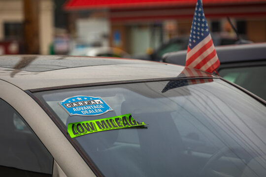 Rockville, MD, USA - 12 January 2023: Dealership Stickers (Carfax, Low Mileage) on the Windshield of a used Car