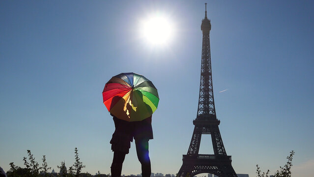 Lovers couple silhouette under multicolor umbrella near Eiffel Tower