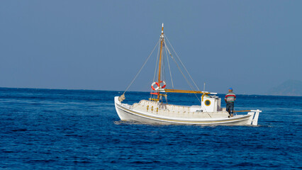Obraz premium Isolated white boat floating over blue sea water surface