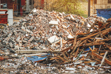 Construction debris piles high in an urban area during the afternoon showcasing the aftermath of...