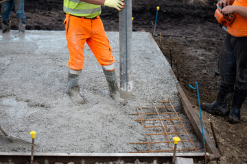 Construction workers pour concrete at a building site, ensuring a strong foundation for future...