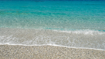 Crystal clear turquoise shallow sea water waves washing the beach