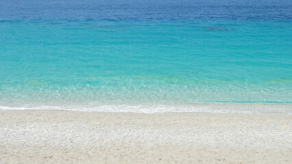 Turquoise shallow water sea waves on white fine sand beach