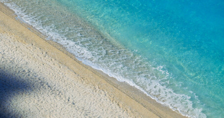 Aerial view of turquoise waves on white beach