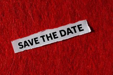Save the date message written on ripped torn paper piece on red background. Conceptual save the...