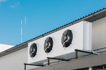 Industrial Cooling Fans on a Commercial Rooftop with Clear Blue Sky