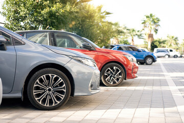 A row of new colorful vehicles on the parking. A line of used cars and trucks for sale.