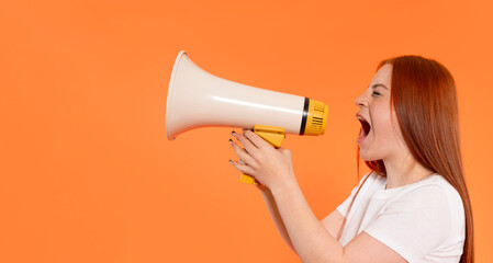 Young woman enthusiastically using megaphone against  vibrant orange background