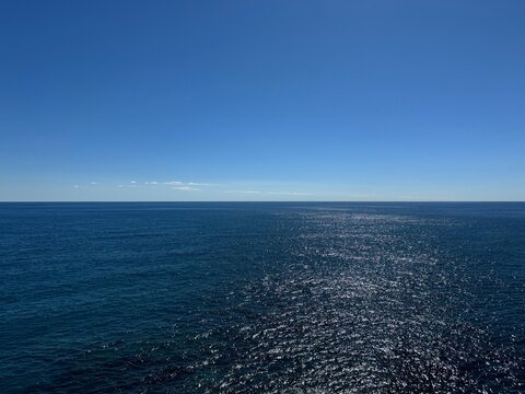Blue sunny sky and sea blue shiny waters.