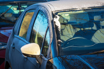 Obraz premium Frost snow covered car door handle and window in england uk