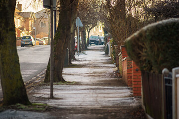 Empty pedestrian footpath covered with icy frost on sunny winter morning in england uk