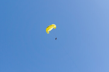 Parasailing Adventure: People Soaring Over the Ocean Behind a Boat