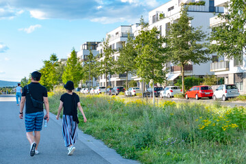 people walking around residential buildings, community with lush greenery, modern architecture and...