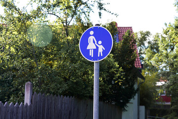 Road sign mother with child on the roadway in a residential area.