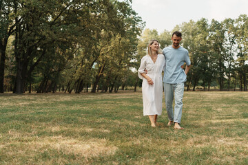 Fototapeta premium Joyful couple enjoying a leisurely walk in a peaceful park setting.