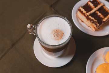 Overhead view of an espresso coffee next to a piece of pastafrola served on a small plate.