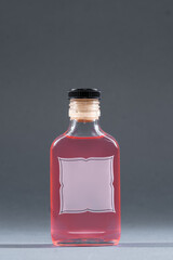 bottle with homemade alcohol tincture or liquor, mockup with empty label, berries and rose